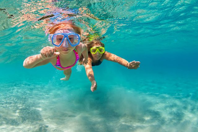 Happy family - mother with baby girl dive underwater with fun in
