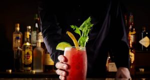 Cocktails to Kick Off the Return of Canadian Football bartender pass a cocktail to a customer