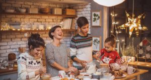 A Sweet, Simple Way to Make Your Holiday Healthier Mother with children in kitchen preparing Christmas cakes