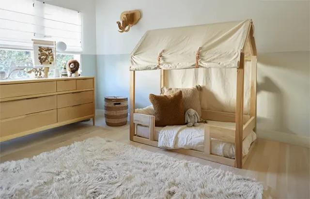 This cozy and inviting nursery features a soft, shaggy rug that perfectly complements the warm, natural tones of the wooden furniture.